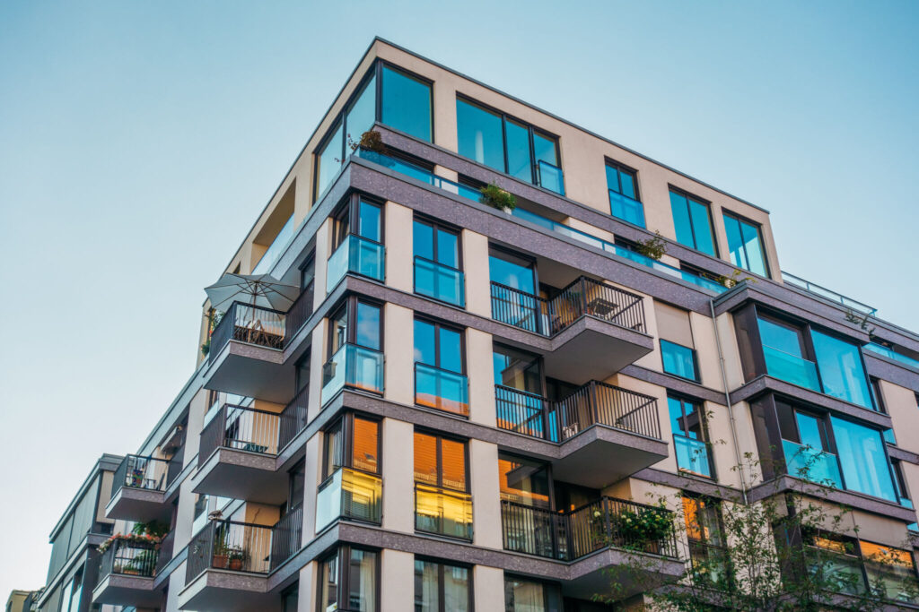 modern corner apartment complex with blue colored windows and light leaks